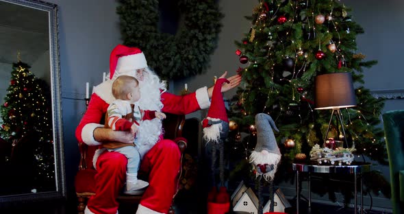 Cute Little Boy Santa Claus Holding Giftbox Look Christmas Tree