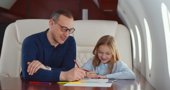 Father and Daughter Drawing with Colorful Pencils Flying Together on Private Jet