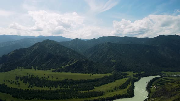 A Mountain River Against the Background of High Green Mountains