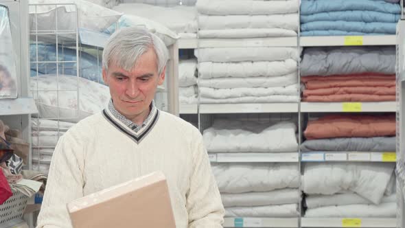 Senior Man Shopping for Bedroom Textile at Furnishings Store