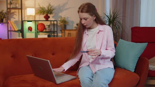 Redhead Child Girl Using Credit Bank Card and Laptop Transferring Money Purchases Online Shopping