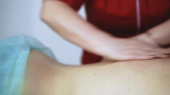 Doctor Does Traditional Massage of Young Female Patient Back