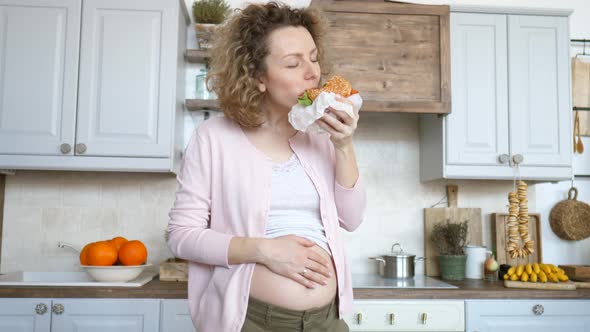 Young Pregnant Woman Eating Burger. Unhealthy Food During Pregnancy Concept.
