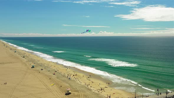 Drone footage of a kite flying over a beach