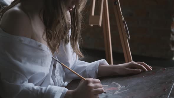 Close-up Portrait of the Artist. Girl Paints a Picture of Sitting on the Floor