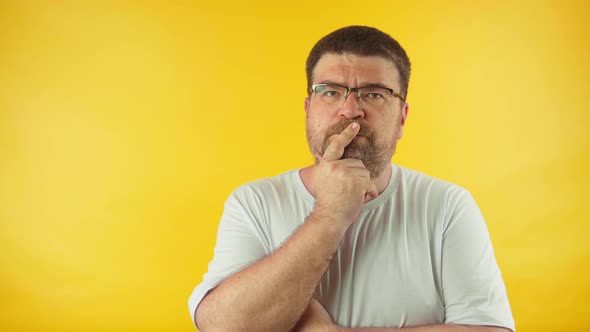 Caucasian middle aged man in white t-shirt thinking and looking