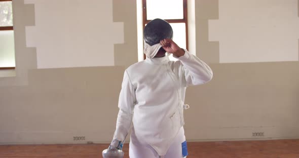 Female fencer athlete during a fencing training in a gym