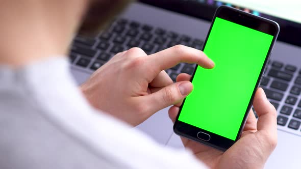 A Black Smartphone with Green Screen for Chroma Key Compositing Swipe Up the Hands of a Man