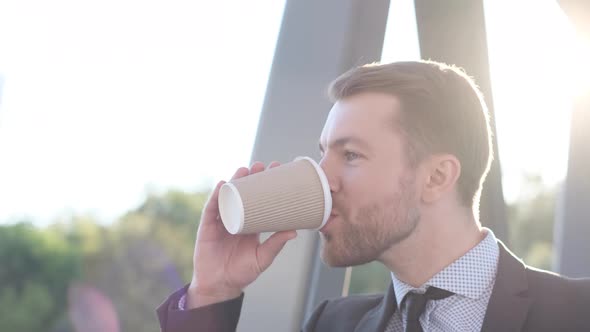 Close Up Portrait of Young Business Man Drinking Coffee on Sunlight Background