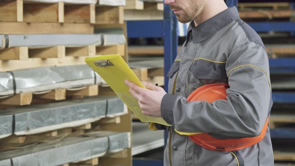 Cropped Shot of a Warehouse Worker Checking Inventory in Stock