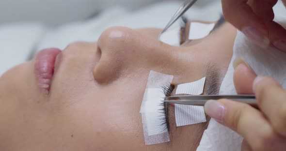 Eyelash extension procedure, professional stylist lengthening female lashes