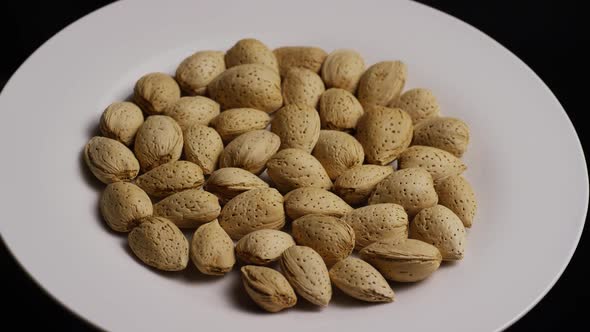 Cinematic, rotating shot of almonds on a white surface - ALMONDS