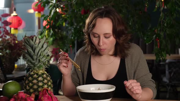 Brownhaired Woman Has Lunch in an Asian Restaurant