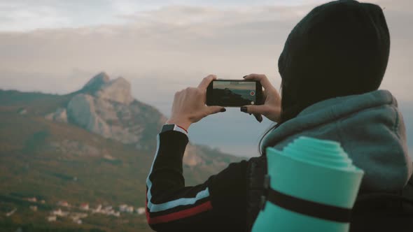 Girl on Mountain Top, Female Tourist Taking Photo of on Cell Smart Phone. Young Woman Traveler