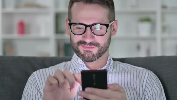 Close Up of Cheerful Young Man Using Smartphone 