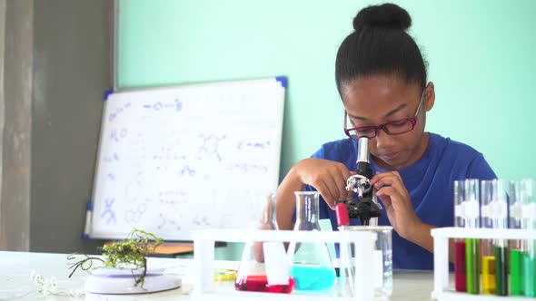 Young African American Kid Using Microscope in Lab