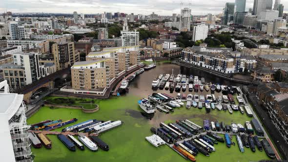 Aerial view of boats docked in the Limehouse waterside and marina and green algae over the water