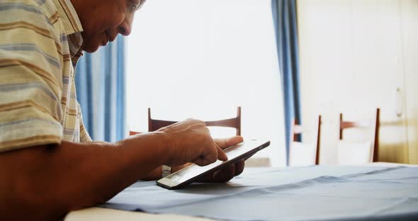 Senior man using digital tablet at table 4k