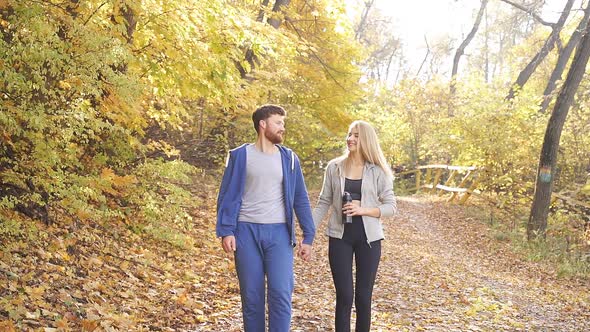 Happy Young Couple Sports Clothes After Run Sunny Day Strolling Through Autumn Forest Among Colorful