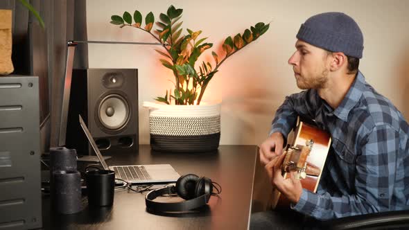 Musician playing chords on acoustic guitar.