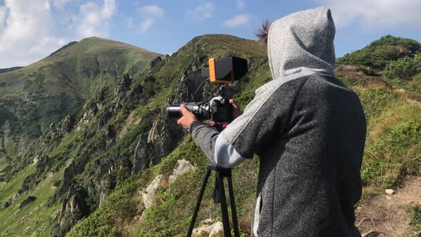 Backview Cameraman Filming Beautiful Landscape of Mountains