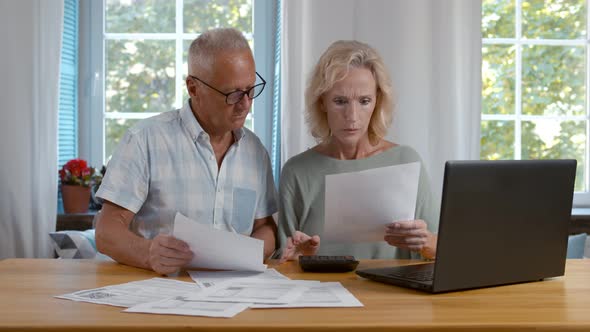Mature Couple Sitting and Managing Expenses at Home.