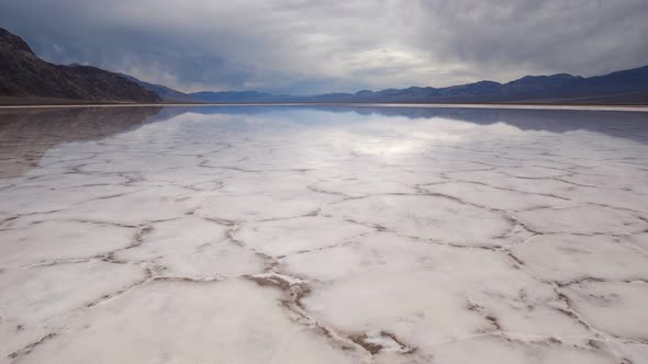 Walking in Mirror Surface of Salt Crust Formations with Water in Badwater Basin, Death Valley