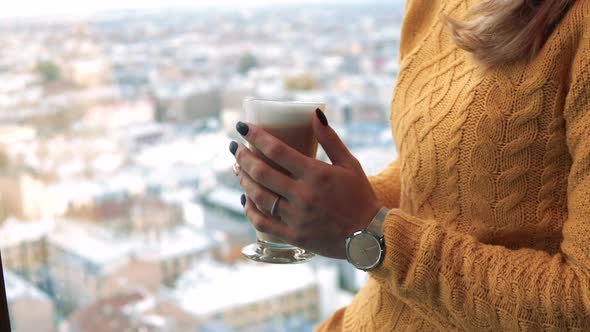 Cup of Coffee in the Hands of a Young Woman