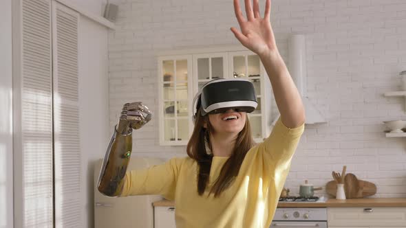 Lady with Bionic Arm Uses Virtual Reality Headset in Kitchen