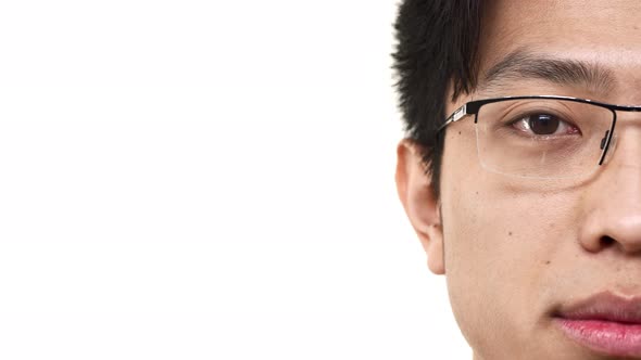Half Side Portrait Closeup of Young Chinese Man Wearing Eyeglasses Looking at Camera with Meaningful