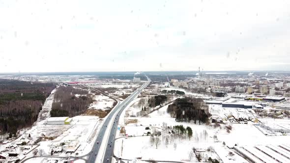 Kaunas city and A1 highway during heavy snowfall in winter season, aerial drone view