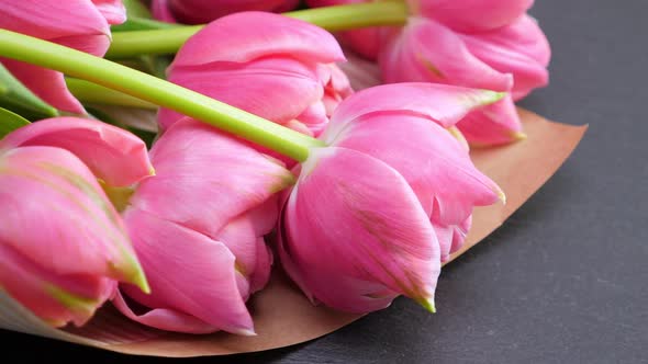 Pink Tulips in Kraft Paper on Black Background