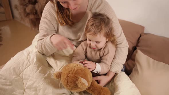 A Mom and Daughter on the Bed Play Talking Cuddles Love