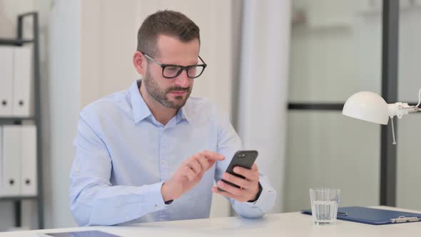 Middle Aged Man Disappointed By Loss on Smartphone