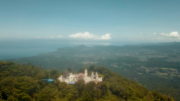 Aerial shot flying towards the Pura Penataran Agung Lempuyang Temple in Bali with a camera tilt down