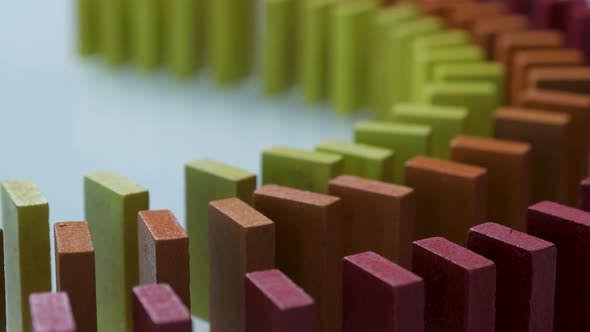 Line up of Dominoes in Rainbow Falling Colors with LGBT Colors of a Hand