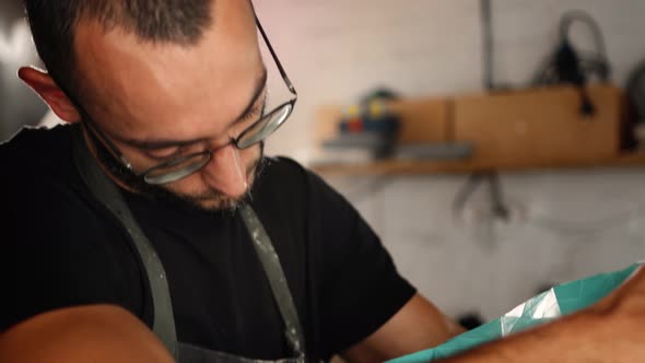 A male creator, sculptor, handyman creates a handmade art object.