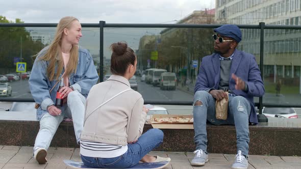 Smiling people sitting on the street with drinks