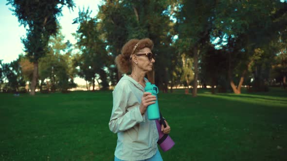 Mature Woman Going to Yoga Class Outdoors