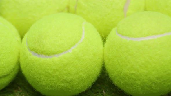 Tennis Balls and Racket on Green Grass Background Close Up
