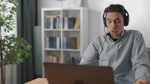 Angry Man in Headset Having Video Chat on Laptop