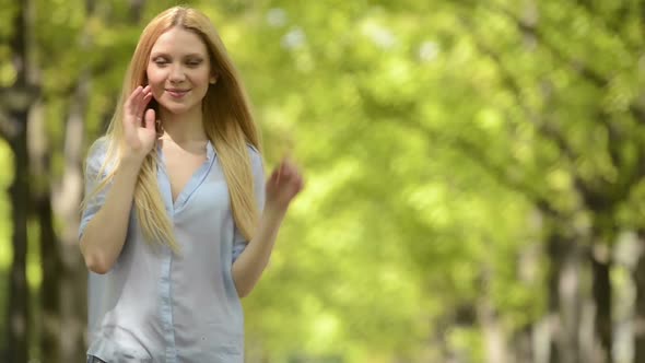 Young Beautiful Blonde Girl Portrait in Summer Day at Urban City Park