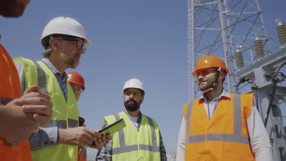 Builders Discussing Power Plant Construction