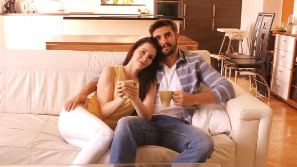 Couple relaxing on sofa and having coffee