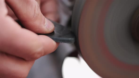 The Craftsman Is Sharpening the Edges of a Belt on a Special Machine