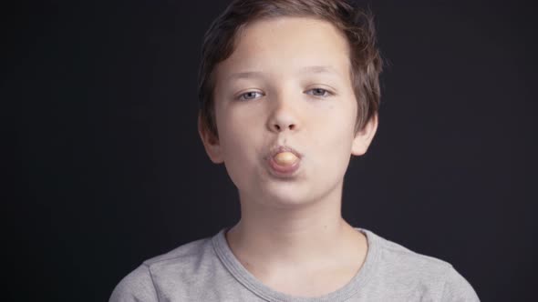 Footage Boy Make Bubble with Chew on Dark Background