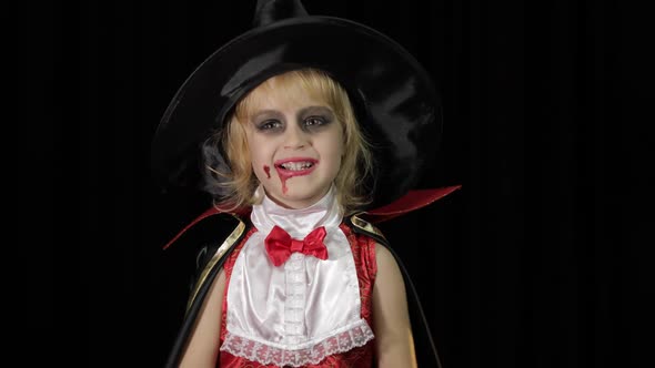 Dracula Child. Girl with Halloween Make-up. Vampire Kid with Blood on Her Face