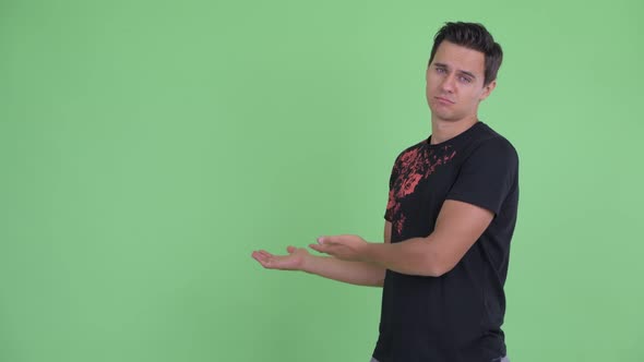 Stressed Young Man Showing To Back and Giving Thumbs Down