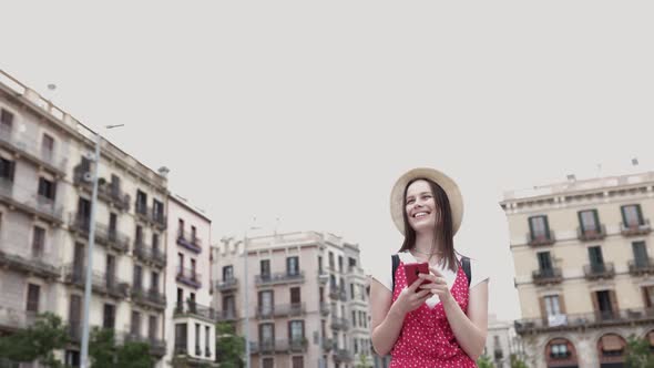 Trendy Hipster Tourist Woman Using Mobile Phone While Visiting Barcelona
