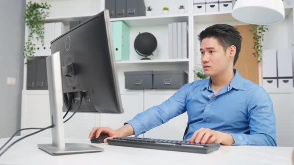 Asian attractive business man sitting on table and working in office.